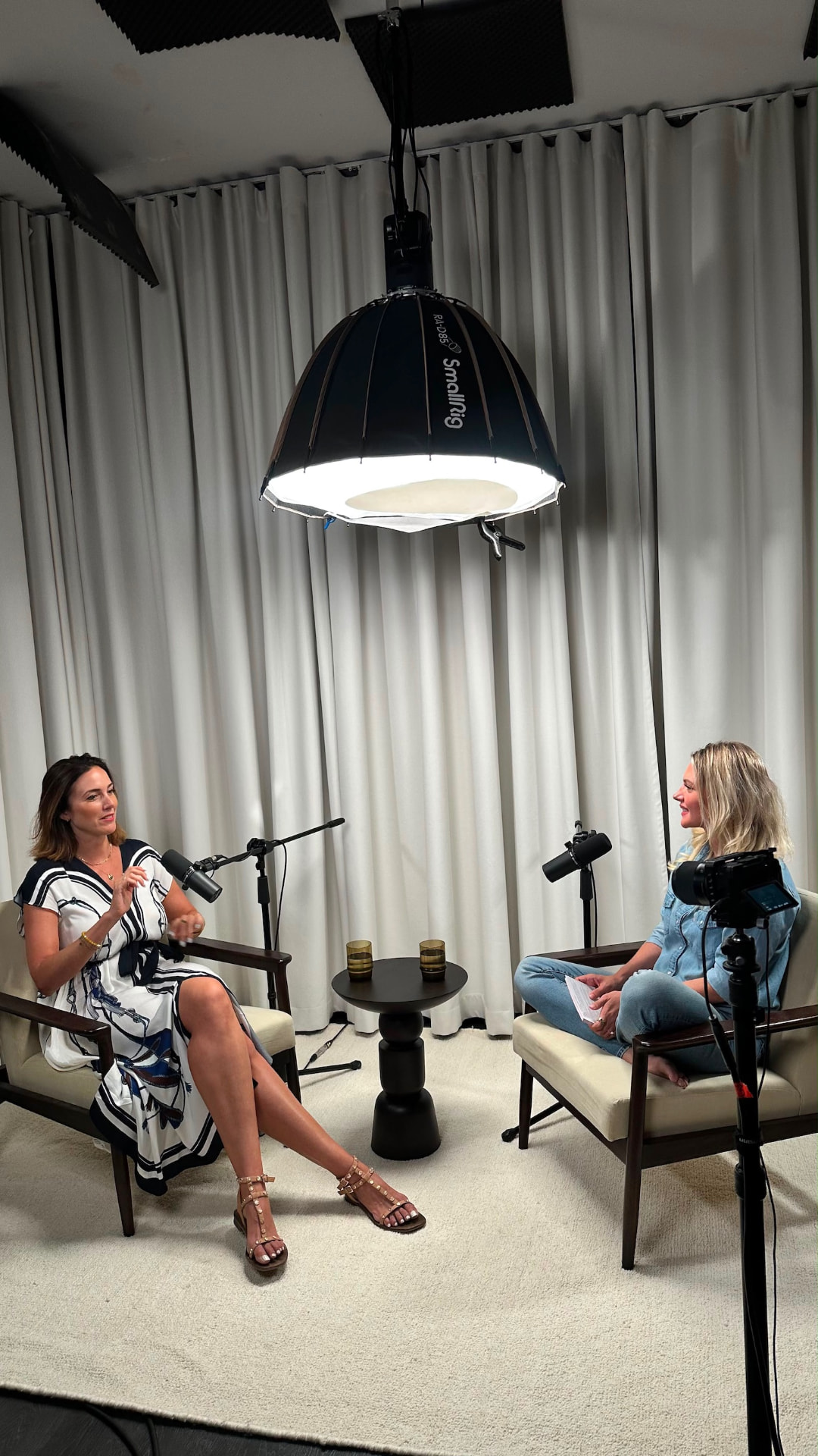 Susanna in conversation with a guest in the recording studio, both seated with microphones